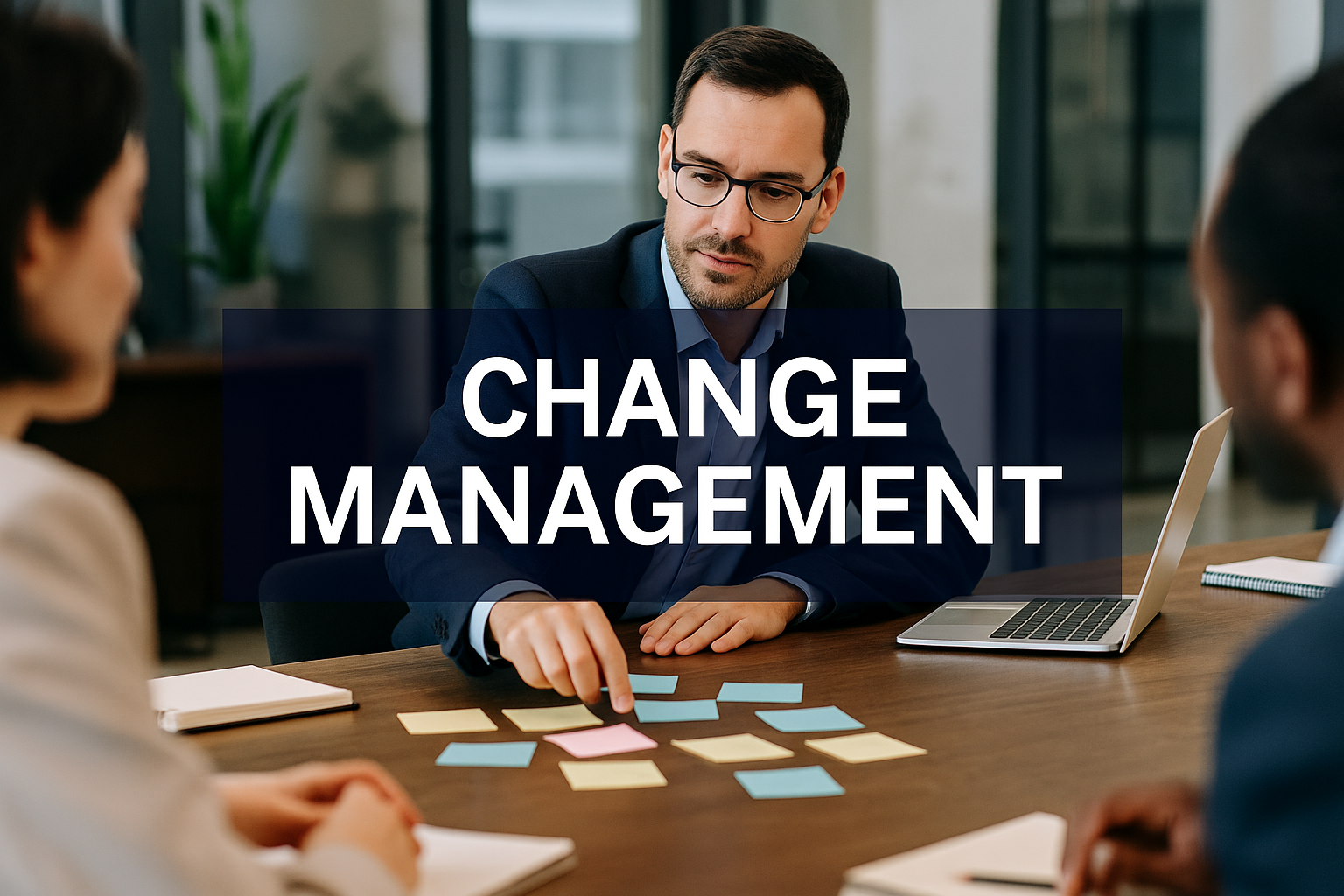 A professional leads a change management discussion in a modern office, pointing to colorful sticky notes on a table while colleagues listen, with the words ‘Change Management’ displayed prominently across the image.